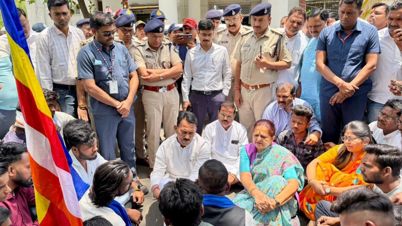 Minister Tulsi Silavat sitting on the road and listening to the protesters.