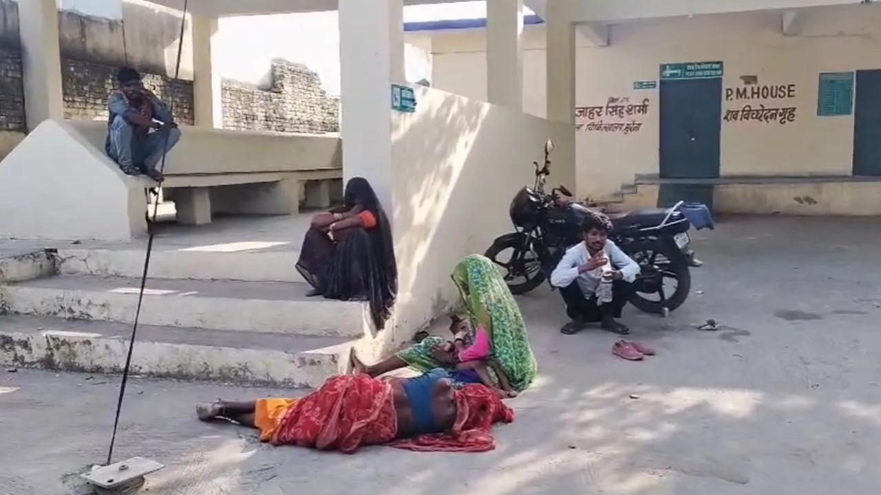 Family members sitting outside the post-mortem house after the woman's death.